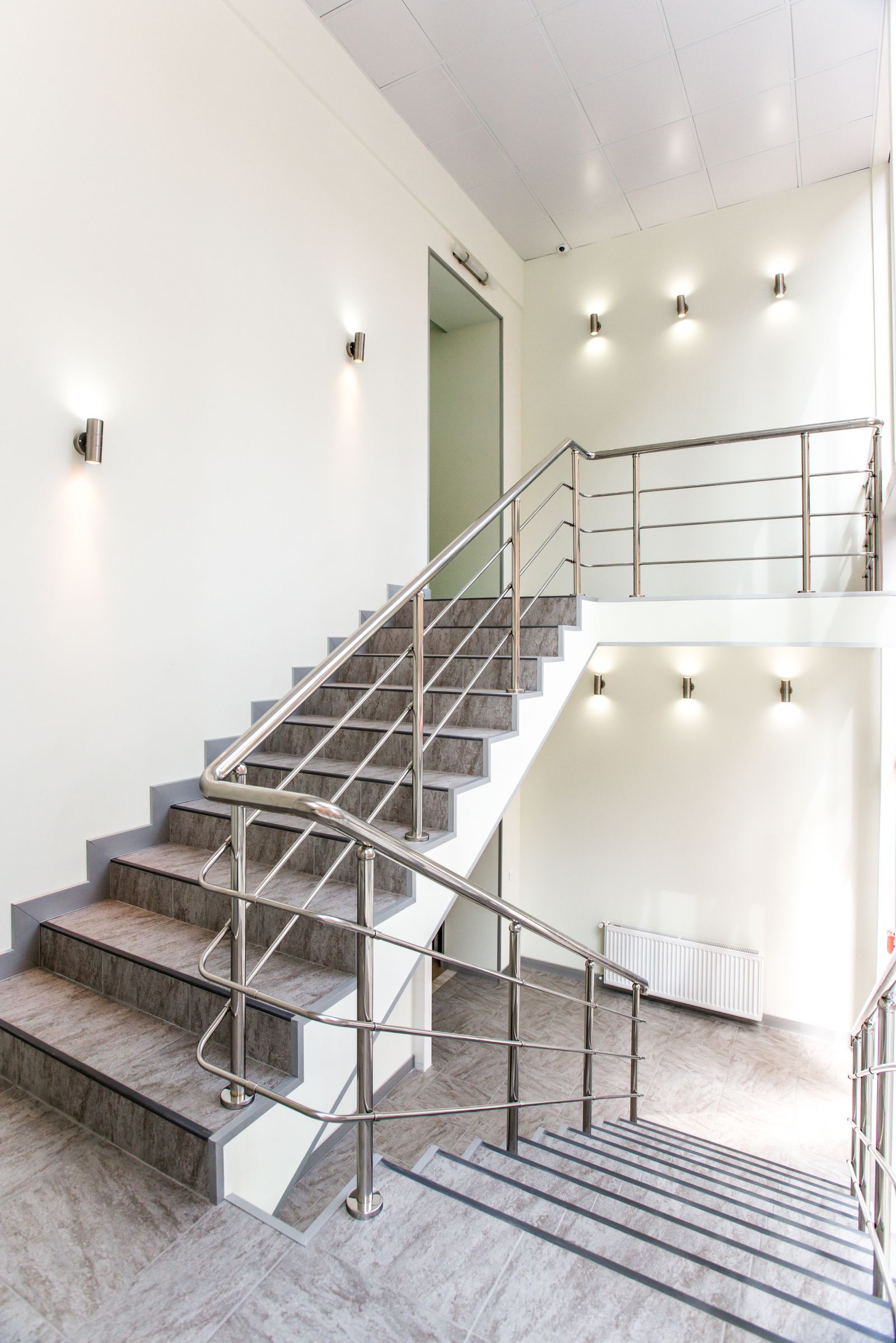 Cầu thang trong nhà với lan can và tay vịn inox, ánh sáng tự nhiên